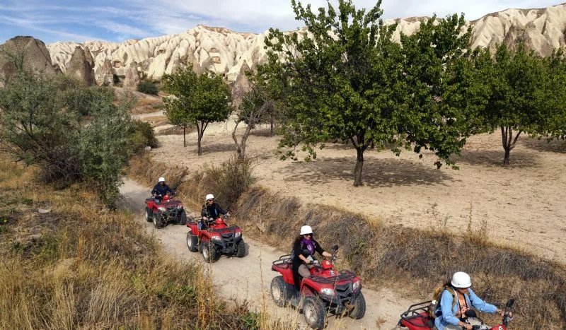 Travelers riding ATVs through the rocky Cappadocia landscape