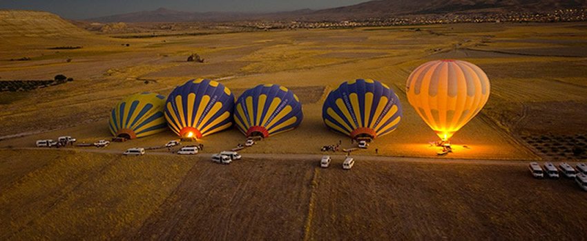 Colorful balloons preparing for launch before sunrise
