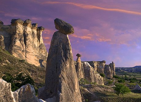 A capped fairy chimney above Cappadocia valley at sunset